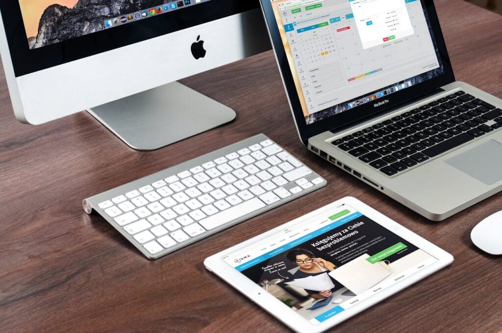 macbook-apple-imac-computer-39284 A sleek office desk setup featuring Apple devices: iMac, MacBook, and iPad.